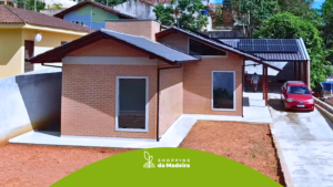 Grande casa de tijolo ecológico com a logo do shopping da madeira na frente